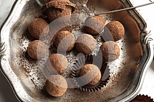 Plate with tasty chocolate truffles on table