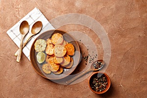 Plate with tasty cooked sweet potatoes, rosemary, sauce and spices, herbs on textured background