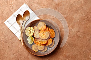 Plate with tasty cooked sweet potatoes, rosemary, sauce and spices, herbs on textured background