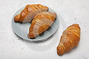 Plate with tasty croissants on stone background. French pastry