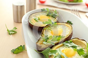 Plate with tasty eggs baked in avocado on table, closeup