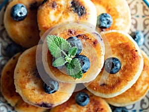 Plate with tasty fluffy pancakes with blueberries, honey