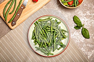 Plate with tasty green beans on table