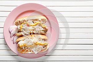 Plate with tasty hot dogs and sauerkraut on white wooden table
