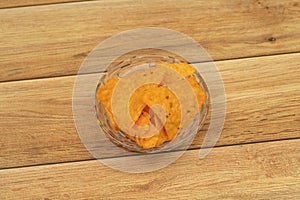 Plate with tasty nachos with wooden background