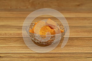 Plate with tasty nachos with wooden background