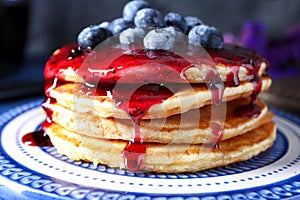 Plate with tasty pancakes, jam and blueberries, closeup