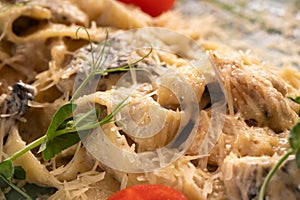 Plate of tasty pasta with chicken fillet and mushrooms in creamy sauce