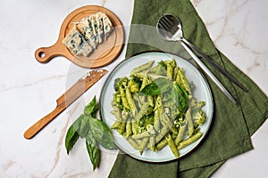 Plate with tasty pesto pasta on light table