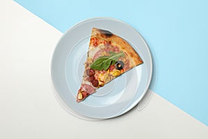 Plate with tasty pizza on two tone background, top view