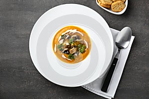 Plate with tasty pumpkin cream soup on grey table