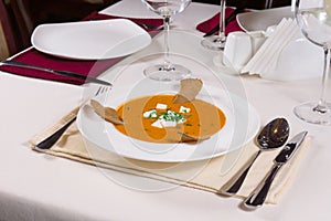 Plate of tasty pumpkin soup served at table