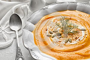 Plate with tasty pumpkin soup on table