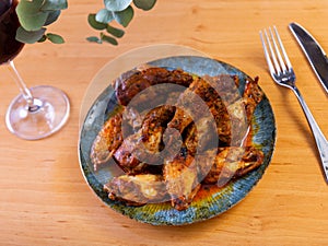 Plate of tasty snack - roasted chicken wings closeup