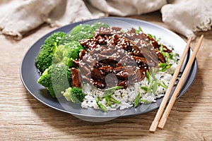 plate of teriyaki beef, rice, broccoli and sesame seeds