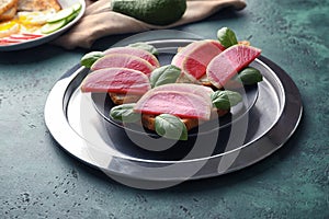 Plate with toasted bread and radish on textured table