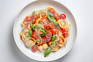 Plate with tortellini pasta, tomatoes and basil