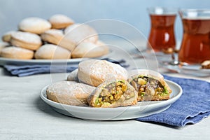 Plate of traditional cookies for Islamic holidays on tea-towel on table.