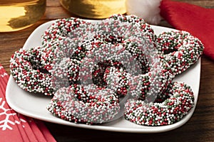 Plate with traditional Dutch Chocolate Christmas rings stuffed with fondant and covered with colorful sprinkles