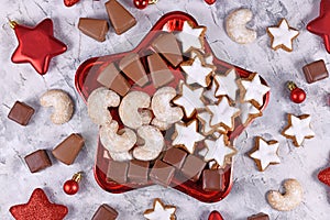 Plate with traditional German Christmas sweets like cinnamon star cookies, `Baumkuchen`, `Dominosteine` and `Vanillekipfe