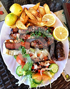 Plate of traditional Greek meat souvlaki with potato and salad