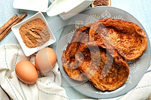 Plate with traditional homemade Torrijas, cinnamon,milk and eggs. Typical Lent and Easter dessert in Spain