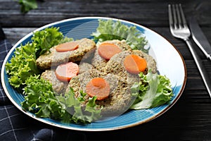 Plate of traditional Passover Pesach gefilte fish on wooden background