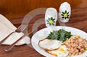 Plate with typical Brazilian meal on a brown table