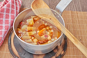 Mondongo a la espanola or cayos a la espanola. Presented in a saucepan on a wooden table View at 45 degrees photo