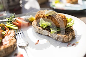 Plate with typical Dutch meal, fried snack croquet with salad on slice of bread