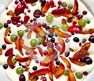 Plate of uncooked clafouti with berries and fruits