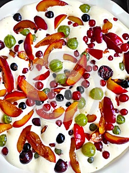 Plate of uncooked clafouti with berries and fruits