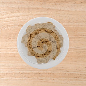 Plate of vanilla animal cookies on a wood table