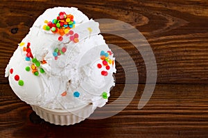 Plate of vanilla ice cream scoop swith sprinkles on wooden background with copy space