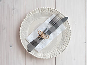 Plate, vintage cutlery and napkin on wooden board. table set