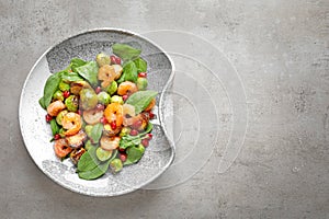 Plate of warm salad with Brussels sprouts on grey table, top view.