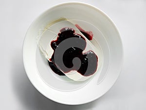 Plate of white ice cream drenched jam