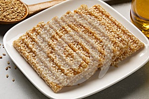 Plate with white sesame snaps close up photo