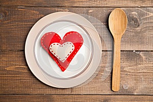 Plate on wooden table with red checked tablecloth