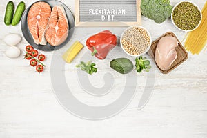 A plate with the words Flexitarian diets, around half-eaten foods. On a light background, vegetables, eggs, salmon and