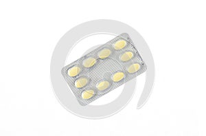 A plate of yellow pills on a white isolated background