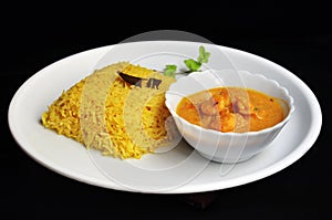 Plate of Yellow pulao and Prawn malai curry with coconut milk photo