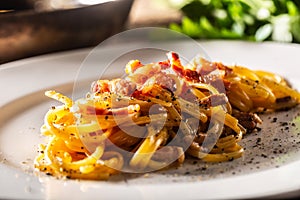 Plated Italian spaghetti carbonara with ham on top