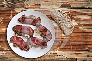 Plateful Of Fried Pork Ham Rashers With Slice Of Integral Brown Bread Set On Old Cracked Wooden Picnic Table