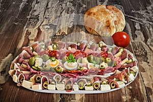 Plateful Of Traditional Serbian Appetizer Dish Meze With Pitta Bread And Tomato Set On Old Garden Table Surface photo