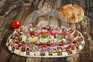 Plateful Of Traditional Serbian Appetizer Dish Meze With Pitta Bread And Cherry Tomato Set On Old Garden Table Surface