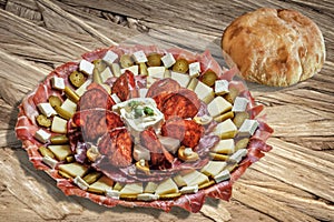 Plateful Of Serbian Appetizer Meze With Pitta Bread Loaf Set On Wooden Chipboard Table Surface photo