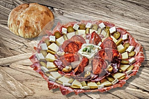 Plateful Of Serbian Appetizer Meze With Pitta Bread Loaf Set On Wooden Chipboard Table Surface