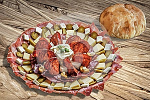 Plateful Of Serbian Appetizer Meze With Pitta Bread Loaf Set On Wooden Chipboard Table Surface