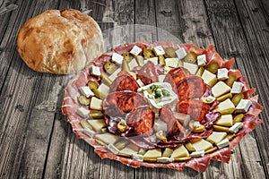 Plateful Of Serbian Appetizer Meze With Pitta Bread Loaf Set On Wooden Chipboard Table Surface photo